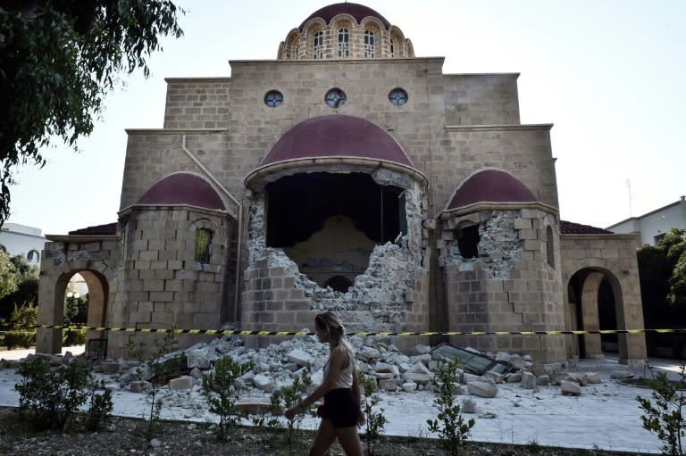 A woman walks past a damaged church on the Greek island of Kos following a 6.7 magnitude earthquake which struck the region on July 21, 2017