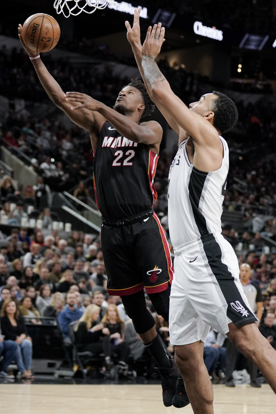 Miami Heat's Jimmy Butler (22) shoots against San Antonio Spurs' Trey Lyles during the first half of an NBA basketball game, Sunday, Jan. 19, 2020, in San Antonio. (AP Photo/Darren Abate)