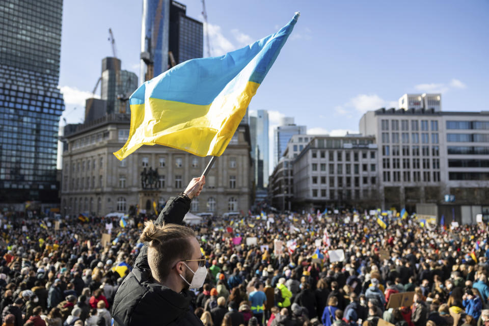 A demonstrator waves a Ukrainian flag at the event "Solidarity with Ukraine - Peace in Eastern Europe" organized by the Green Party in Frankfurt, Germany, Saturday, Feb. 26, 2022. (Hannes P. Albert/dpa via AP)