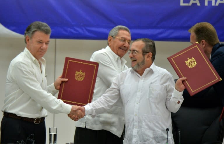 Colombian President Juan Manuel Santos (L) and FARC leader Timoleon Jimenez shake hands during the signing of the peace agreement on June 23, 2016