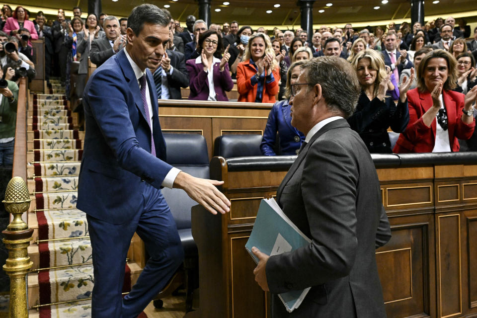 Spain's acting Prime Minister Pedro Sanchez, left prepares to shake hands with conservative opposition leader Alberto Nunez Feijoo after Sanchez was chosen by a majority of legislators to form a new government after a parliamentary vote at the Spanish Parliament in Madrid, Spain, Thursday, Nov. 16, 2023. (Javier Soriano/Pool Photo via AP)