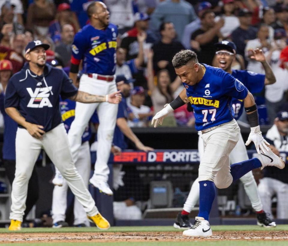 Venezuela infielder Wilfredo Jose Tovar (77) scores a run after infielder Hernan Alejandro Perez (26) hit a triple against Dominican Republic in the fifth inning of their Caribbean Series baseball game at loanDepot park on Friday, Feb. 9, 2024, in Miami, Fla.