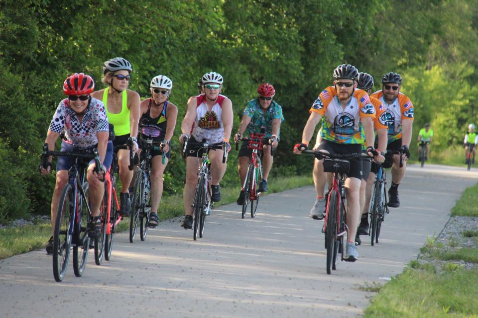 Riders make their way into Dallas Center on the Raccoon River Valley Trail as part of the Bacoon Ride in June 2022.
