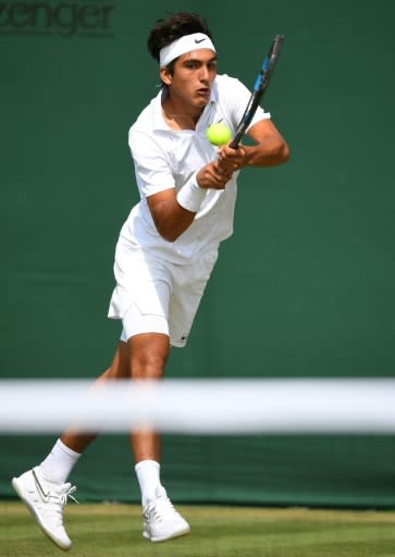 Argentinian boys' singles player Roman Burruchaga hits a return to Pablo Llamas of Spain