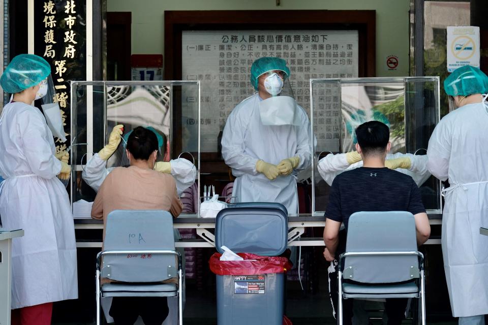 <p>Medical staffers collect samples from local residents during a COVID-19 corona virus testing at the Xindian District in New Taipei City </p> (AFP via Getty Images)