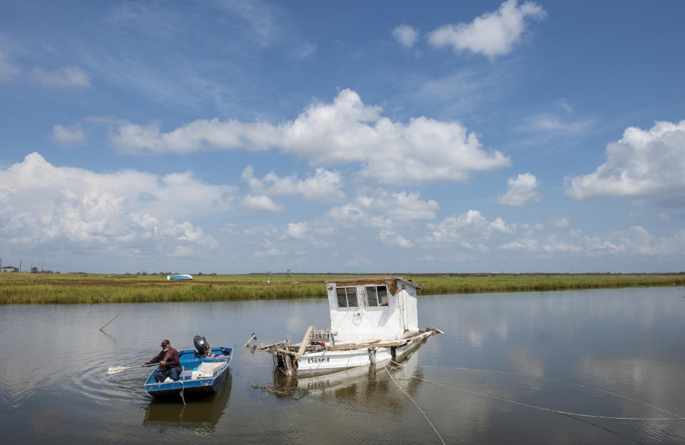 Nicholas Bartholomew, 78, who has been a shrimper since he was 15-years-old, paddles out to check on his boat that floated away from its mooring on Grand Bayou near Highway 23 in Plaquemines Parish over a week after Hurricane Ida on Tuesday, Sept. 7, 2021. (Chris Granger/The Times-Picayune/The New Orleans Advocate via AP)