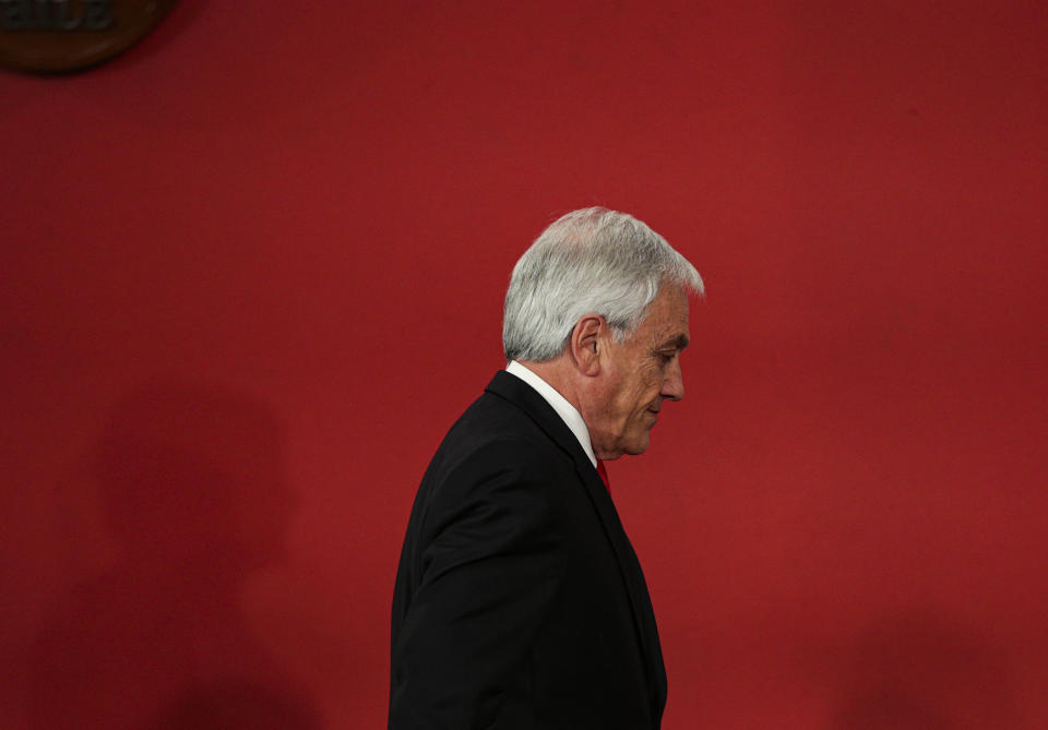 FILE - In this Oct. 28, 2019 file photo, Chile's President Sebastian Pinera leaves at the end of a ceremony introducing his reshuffled Cabinet, at La Moneda presidential palace in Santiago, Chile. Two-term President Pinera has called to elect an assembly on April 11, 2021, for a new constitution, even though he cannot run in a general election on Nov. 21. (AP Photo/Esteban Felix, File)