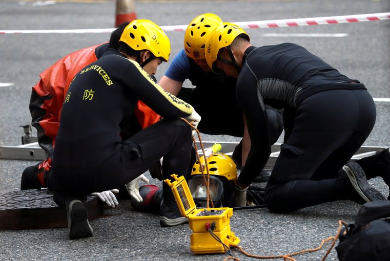 A rescue diver from the Fire Service department enters the sewage system to search anti-government protesters who escaped from the Hong Kong Polytechnic University (PolyU) after being barricaded by police officers