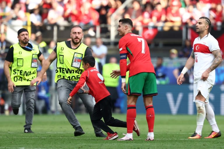 A young fan managed to get a selfie with Cristiano Ronaldo before trying to evade stadium security (FRANCK FIFE)