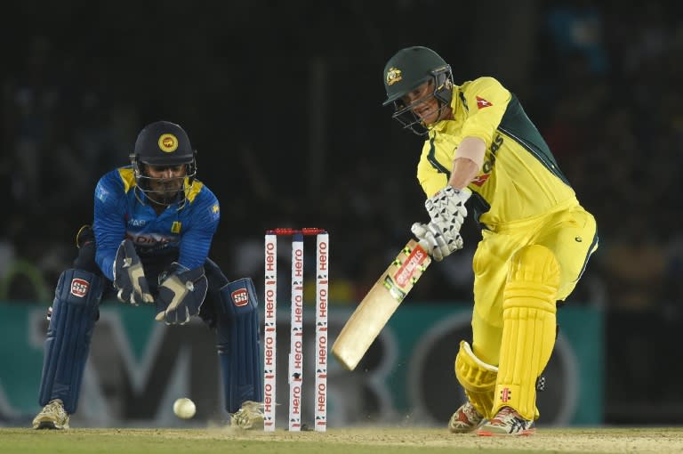 Australian cricketer George Bailey (R) plays a shot as Sri Lankan wicketkeeper Kusal Perera looks on on August 28, 2016