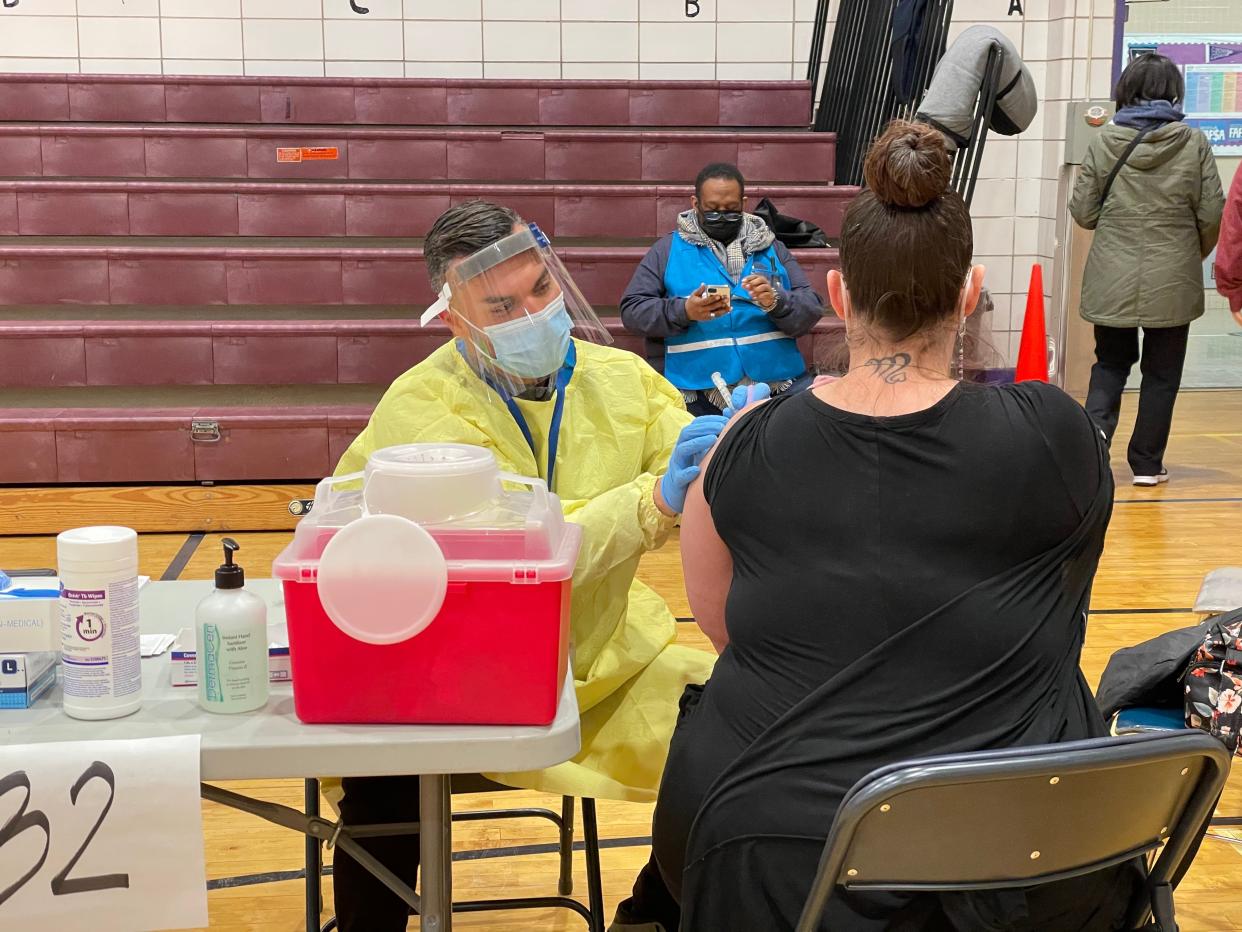 A New York teacher receives the first dose of Moderna’s Covid-19 vaccine on Tuesday, 13 January, at one of New York City’s new vaccination hubs (Danielle Zoellner/The Independent)