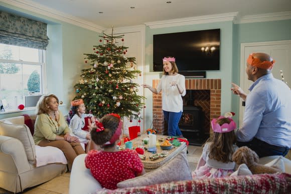 A family gathers around a Christmas tree.