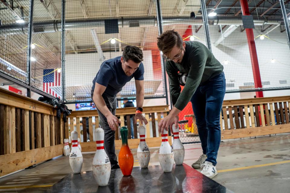 Scott Boisvert, left, of Brooklyn, N.Y., and teammate Max Smith, of Ann Arbor, set up pins before playing another game at the Fowling Warehouse in Ypsilanti on Friday, Nov. 3, 2023.