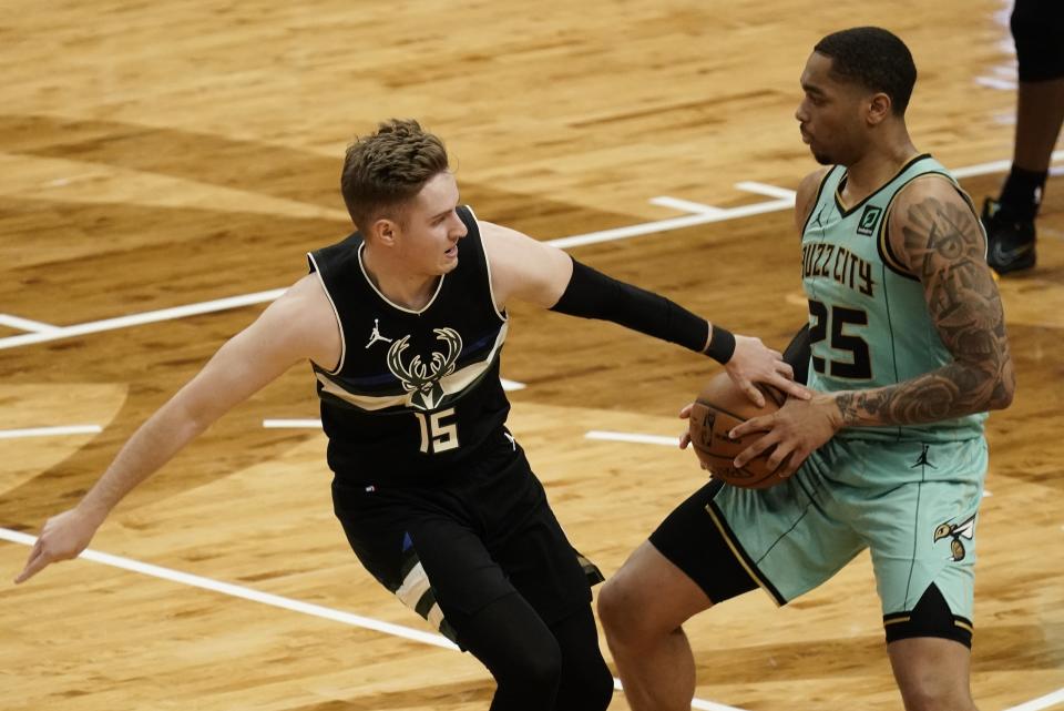 Milwaukee Bucks' Sam Merrill tries to steal the ball from Charlotte Hornets' P.J. Washington during the first half of an NBA basketball game Friday, April 9, 2021, in Milwaukee. (AP Photo/Morry Gash)