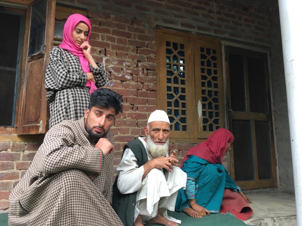 In this Monday, Aug. 26, photo, A Kashmiri man Mohammed Abdullah, center, sits with family members at their home and talks to reporters about his grandson who was picked up in a nocturnal raid recently and shifted to a jail in India’s northern city of Agra, in southern Karimabad village, Indian controlled Kashmir. The main city of Indian-controlled Kashmir presents a mostly deserted and subdued look, woven in a maze of razor wire. But drive out into the rural hinterland and residents in village after village narrate horrors of regular nightly raids by Indian army soldiers. The abuses in the nighttime raids by troops began in early August as New Delhi took its action on Kashmir, according to interviews with at least 200 people. The change in status nullified decades-old constitutional provisions that gave Jammu and Kashmir some political autonomy and land inheritance rights. (AP Photo/Aijaz Hussain)