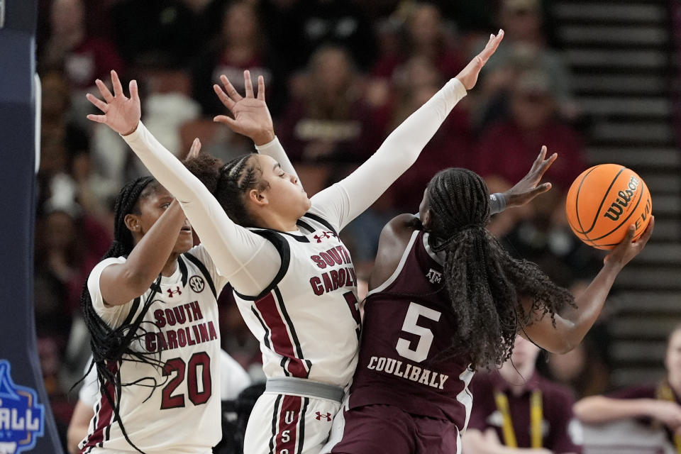 Texas A&M guard Aicha Coulibaly, right, shoots over South Carolina forward Sania Feagin (20) and guard Tessa Johnson during the second half of an NCAA college basketball game at the Southeastern Conference women's tournament Friday, March 8, 2024, in Greenville, S.C. (AP Photo/Chris Carlson)
