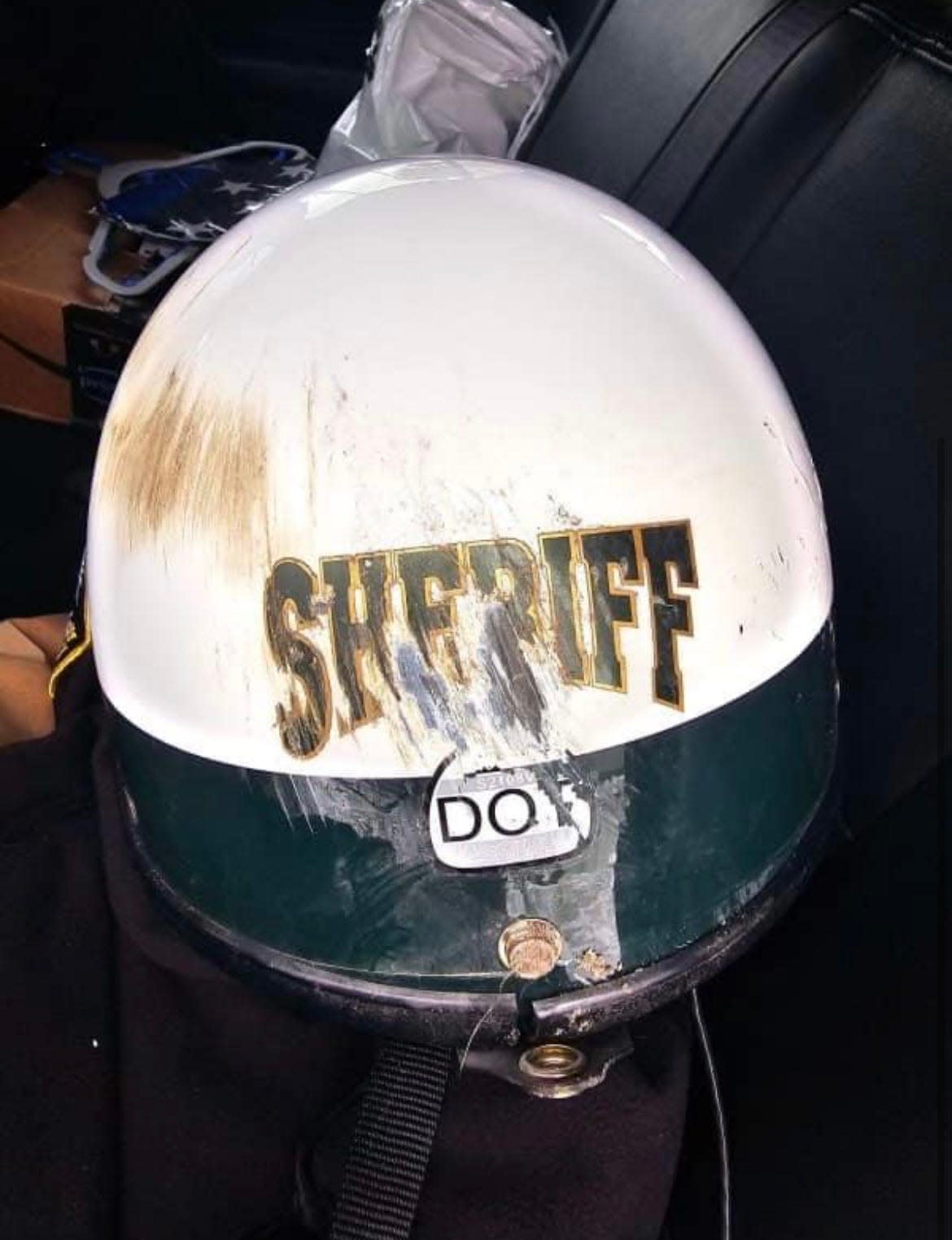 Flagler County Sheriff's Office Deputy First Class Benjamin Stamps' helmet sustained damage but protected his head when a car crossed into his lane and collided with his patrol motorcycle as he rode to work on Tuesday, the sheriff's office stated.