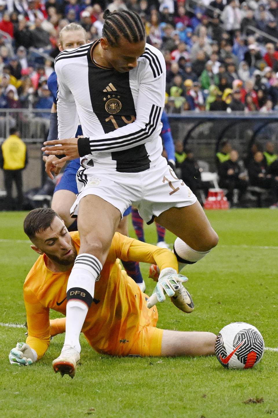 Germany's Leroy Sane, front, leaps over United States goalkeeper Matt Turner during an international friendly soccer match at Pratt & Whitney Stadium at Rentschler Field, Saturday, Oct. 14, 2023, in East Hartford, Conn. (AP Photo/Jessica Hill)