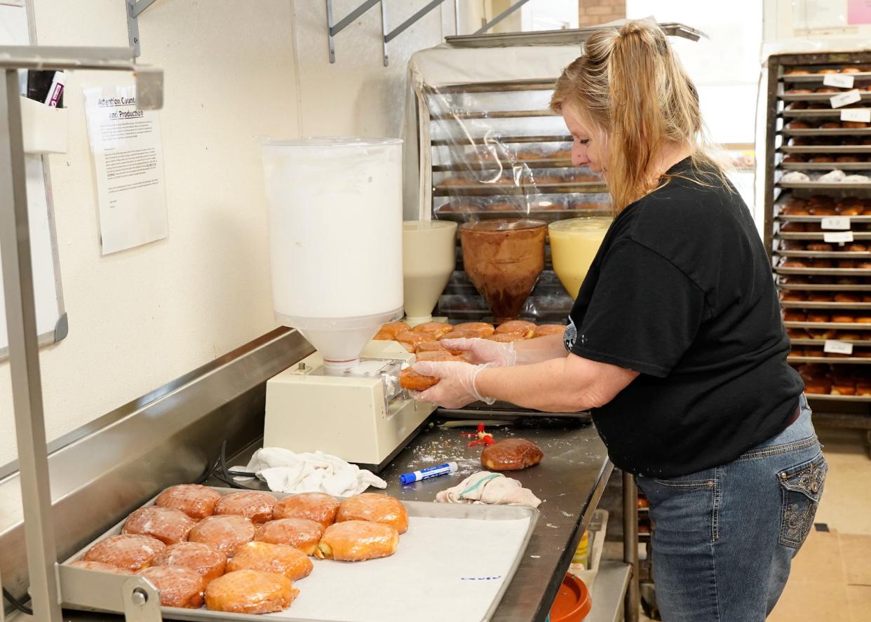 Morning Fresh Bakeries employee Carrie Six of Sand Creek fills glazed paczki with crème filling Monday afternoon in preparation for Fat Tuesday, also known as Paczki Day, which is today.