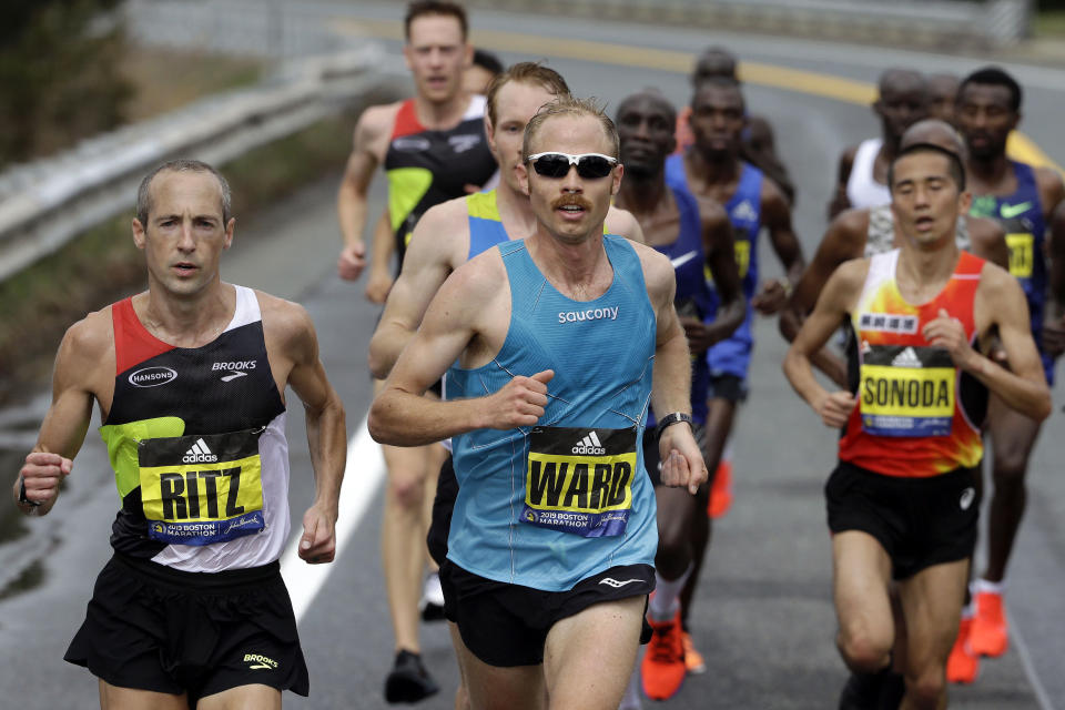 FILE - In this April 15, 2019, file photo, Jared Ward, center, of Mapleton, Utah, leads the pack in front as they run the course during the 123rd Boston Marathon in Natick, Mass. Footwear will be a the forefront at the U.S. Olympic marathon trials this weekend in Atlanta. No matter what time the marathoners turn in or how well they run, the they know their shoes will be the real headliner.(AP Photo/Steven Senne, File)