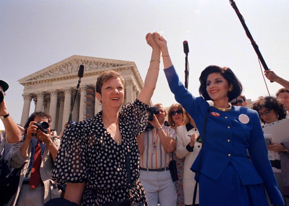 FILE - Norma McCorvey, Jane Roe in the 1973 court case, left, and her attorney Gloria Allred hold hands as they leave the Supreme Court building in Washington, DC., Wednesday, April 26, 1989. . (AP Photo/J. Scott Applewhite, File)