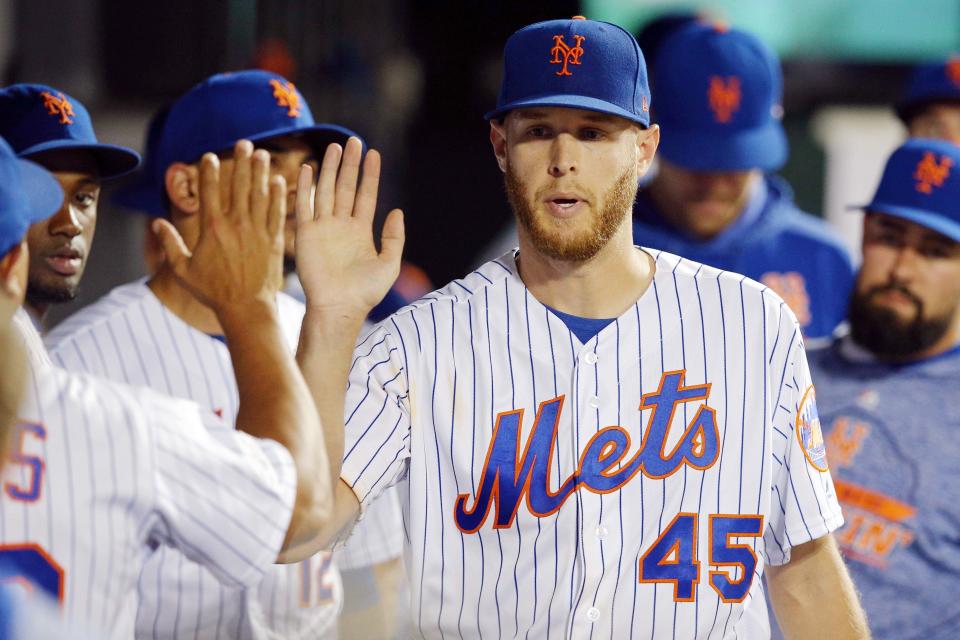 Jul 2, 2019; New York City, NY, USA; New York Mets starting pitcher Zack Wheeler (45) is greeted in the dugout by teammates after coming out of the game against the New York Yankees during the seventh inning at Citi Field. Mandatory Credit: Brad Penner-USA TODAY Sports