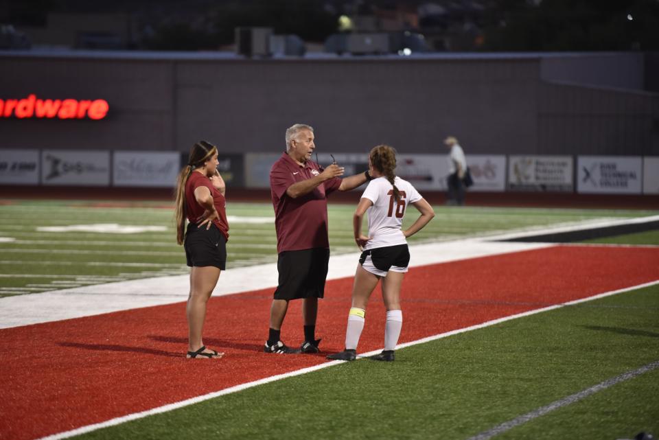 Keana Tolman gets a teaching lesson from head coach Scott Kamachi in the first half of Cedar's win against Hurricane.