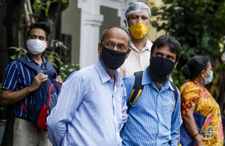 Commuters with face mask as a precaution against the coronavirus wait for a bus in Kolkata, India, Thursday, July 9, 2020. India has overtaken Russia to become the third worst-affected nation by the coronavirus pandemic. (AP Photo/Bikas Das)