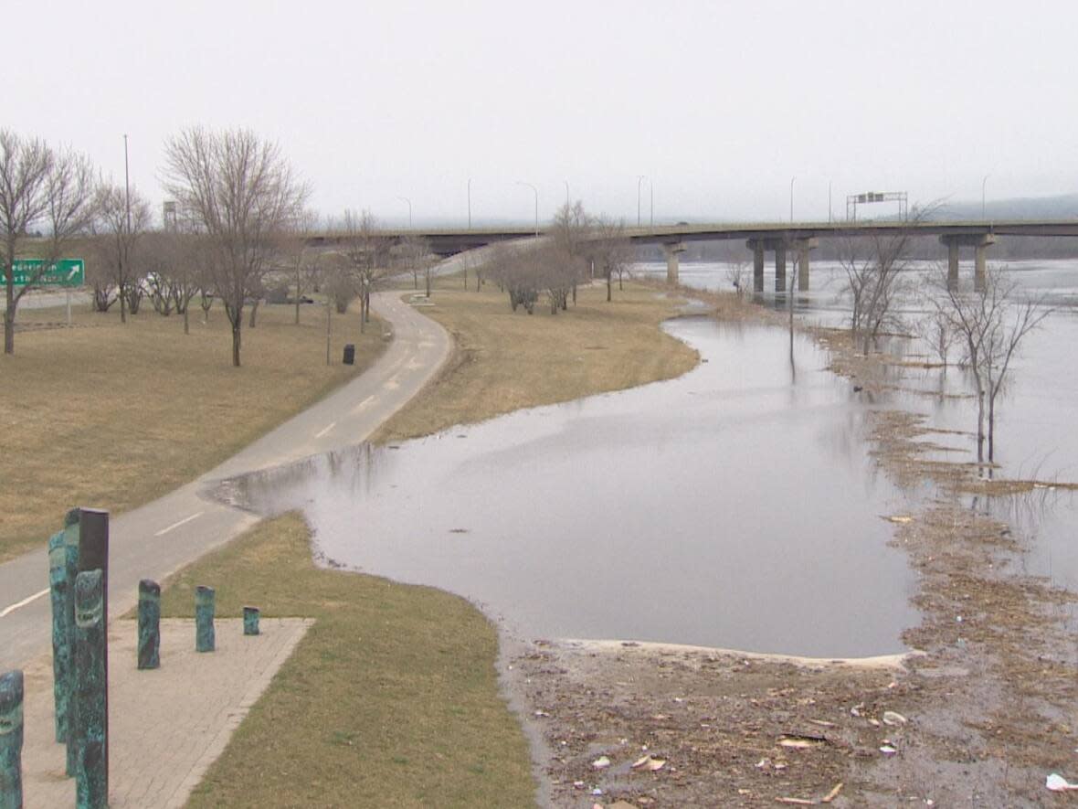 Fredericton is set to hit flood stage on Wednesday. On Monday, water had flooded onto the green on the south side, moving onto the riverfront walking trail. (Pat Richard/CBC - image credit)