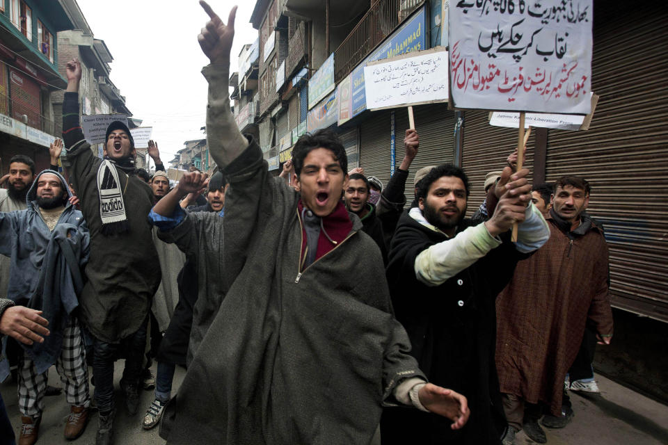 FILE - In this Friday, Jan. 31, 2014, file photo, Activists of Jammu Kashmir Liberation Front (JKLF) shout slogans during a protest against the Indian army's decision to close a fake encounter case against five soldiers in connection with the killing of five Kashmiris in Pathribal in March 2000, in Srinagar, India. In a separate case, the Indian military on Friday, Sept. 18, said its soldiers in Kashmir exceeded their legal powers in the killings of three local men it had described as Pakistani terrorists on July 18, 2020. Police ordered an investigation into the accusation of a staged gunbattle, and the results have not yet been released. The results of the police probe are likely to spark an outcry among Kashmiri activists who for years have accused Indian troops of abusing their powers and repeatedly targeting civilians. Placard at background right reads, "AFSPA and other black laws are giving Indian soldiers a license to kill." (AP Photo/Dar Yasin)