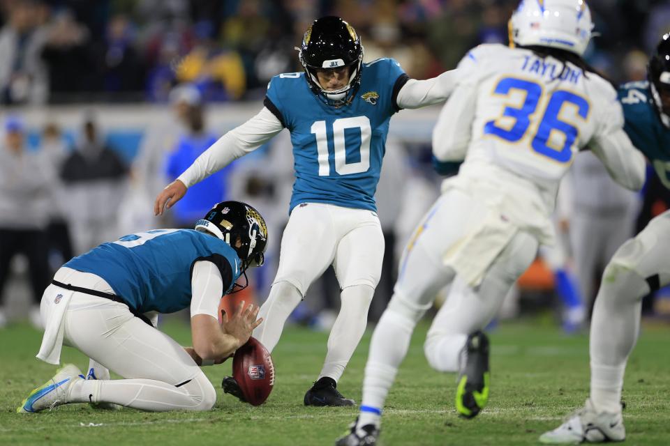 Jacksonville Jaguars place kicker Riley Patterson (10) kicks a game-winning field goal as punter Logan Cooke (9) holds during the fourth quarter of an NFL first round playoff football matchup Saturday, Jan. 14, 2023 at TIAA Bank Field in Jacksonville, Fla. Jacksonville Jaguars edged the Los Angeles Chargers on a field goal 31-30. [Corey Perrine/Florida Times-Union]