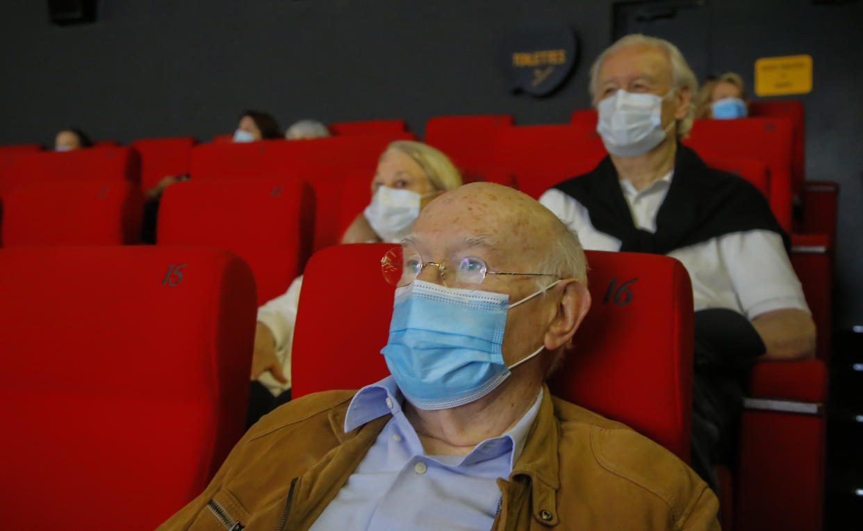 People wear protective masks as they wait for the screening of a movie in Paris, Monday, June 22, 2020. (AP Photo/Michel Euler)