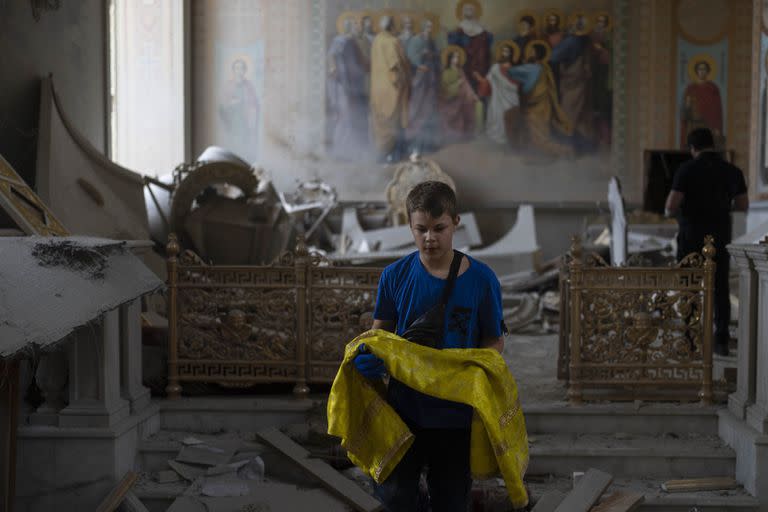 Un niño ayuda a rescatar artículos en la Catedral de la Transfiguración de Odesa después de que fue gravemente dañada por los ataques con misiles rusos en Odesa, Ucrania, el domingo 23 de julio de 2023. (Foto AP/Jae C. Hong)