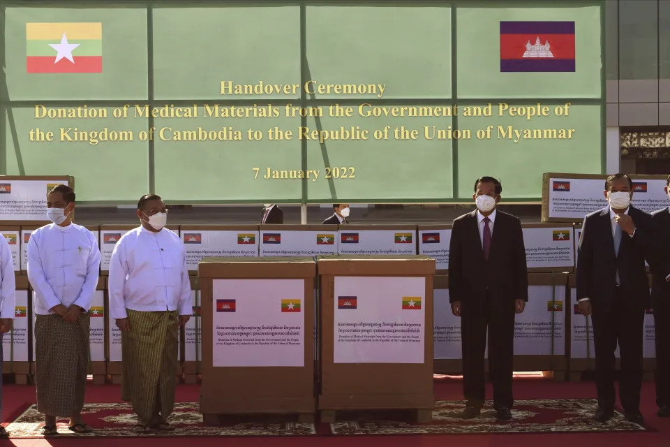 In this photo provided by An Khoun Sam Aun/National Television of Cambodia, Cambodian Prime Minister Hun Sen, second from right, poses for photographs together with Myanmar Foreign Minister Wunna Maung Lwin, second from left, during a handing over of the medical materials to Myanmar, in Naypyitaw, Friday, Jan 7, 2022. (An Khoun SamAun/National Television of Cambodia via AP)