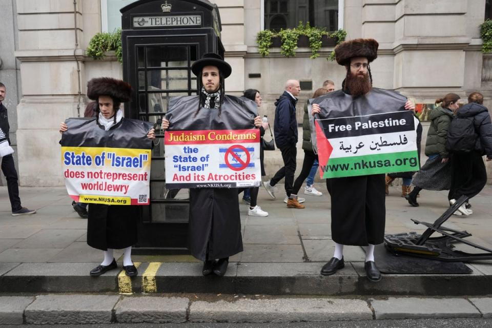 Three Jewish men who belong to the Neturei Karta sect holding placards reading “Judaism condemns the state of Israel” (Jeff Moore/PA)