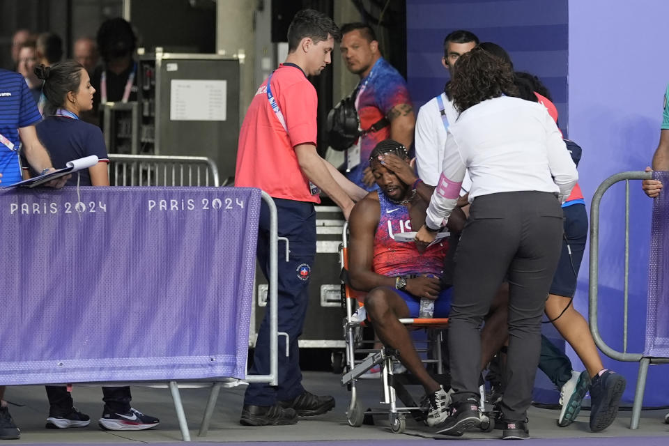 Noah Lyles, dari Amerika Serikat, dibantu keluar lintasan setelah final lari 200 meter putra di Olimpiade Musim Panas 2024, Kamis, 8 Agustus 2024, di Saint-Denis, Prancis. (Foto AP/Matthias Schrader)