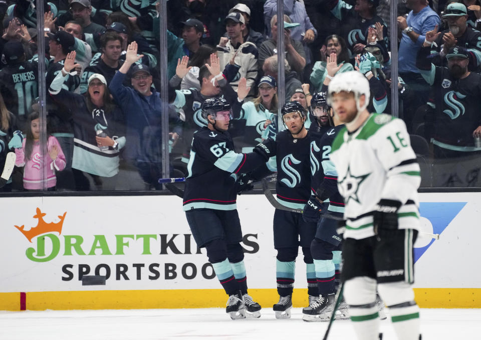 Seattle Kraken center Morgan Geekie (67) greets center Jaden Schwartz after Schwartz scored against the Dallas Stars during the second period of Game 4 of an NHL hockey Stanley Cup second-round playoff series Tuesday, May 9, 2023, in Seattle. (AP Photo/Lindsey Wasson)