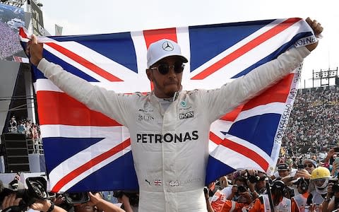 British driver Lewis Hamilton celebrating after winning his fourth Formula One world title despite finishing the Mexican Grand Prix in ninth place, at the Hermanos Rodriguez circuit in Mexico City - Credit: AFP/Getty Images