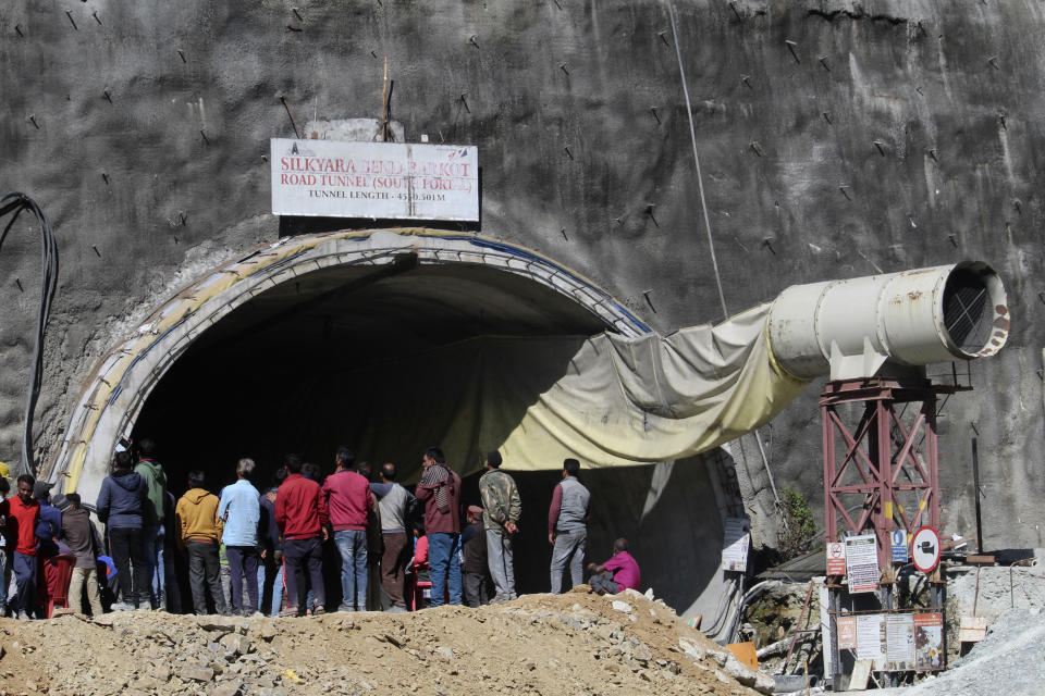 People watch rescue and relief operations at the site of an under-construction road tunnel that collapsed in mountainous Uttarakhand state, India, Wednesday, Nov. 15, 2023. Rescuers have been trying to drill wide pipes through excavated rubble to create a passage to free 40 construction workers trapped since Sunday. About 200 disaster relief personnel have been using drilling equipment and excavators in the rescue operation with the plan to push steel pipes 2.5-foot (0.76 meter) -wide through an opening of excavated debris with the help of hydraulic jacks to safely pull out the stranded workers. (AP Photo)