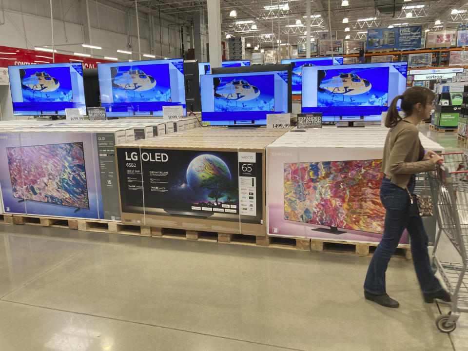 A shopper passes by a display of big-screen televisions in a Costco warehouse Friday, Oct. 14, 2022, in Sheridan, Colo. (AP Photo/David Zalubowski)