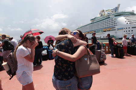 Women hug as people line up to board a Royal Caribbean cruise ship that will take them to the U.S. mainland, in San Juan, Puerto Rico September 28, 2017. REUTERS/Alvin Baez