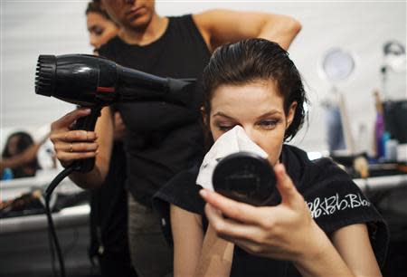 A model has her hair and make up done prior to the presentation of the Vera Wang Spring/Summer 2014 collection during New York Fashion Week in New York, September 10, 2013. REUTERS/Keith Bedford