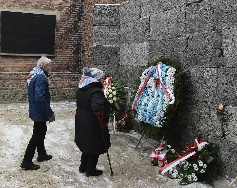 Former prisoners place candles and flowers at the Death Wall marking the 74th anniversary of the liberation of KL Auschwitz-Birkenau, in Oswiecim, Poland, Sunday, Jan. 27, 2019.(AP Photo/Czarek Sokolowski)