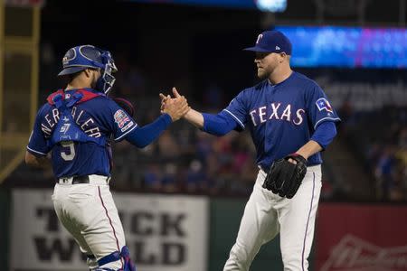 FILE PHOTO: May 4, 2019; Arlington, TX, USA; Texas Rangers catcher Isiah Kiner-Falefa (9) and relief pitcher Shawn Kelley (27) celebrate the win over the Toronto Blue Jays at Globe Life Park in Arlington. Mandatory Credit: Jerome Miron-USA TODAY Sports
