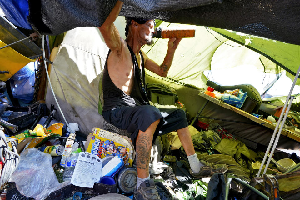 FILE - Charles Sanders, 59, sits in his tent inside a homeless encampment called "The Zone," Friday, July 14, 2023, in downtown Phoenix. The United States is ill-prepared to ensure housing and care for the swelling ranks of America's older people. That's the conclusion of a new report being released Thursday by Harvard University’s Joint Center for Housing Studies. (AP Photo/Matt York, File)