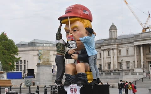 A 16ft talking robot of US President Donald Trump sitting on a gold toilet in Trafalgar Square - Credit: Jacob King/PA