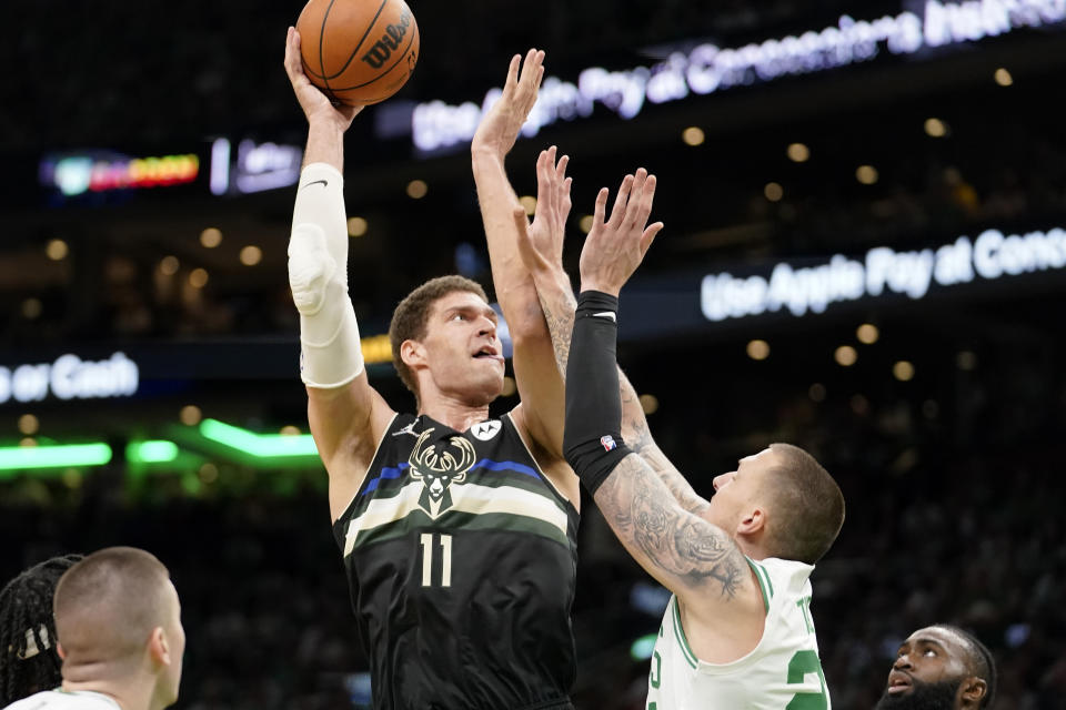 Milwaukee Bucks center Brook Lopez (11) shoots at the basket as Boston Celtics center Daniel Theis, front right, defends during the first half of Game 7 of an NBA basketball Eastern Conference semifinals playoff series, Sunday, May 15, 2022, in Boston. (AP Photo/Steven Senne)