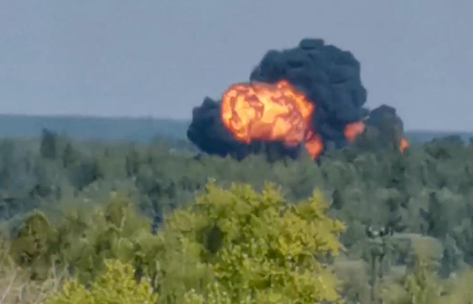 In this handout photo taken from video provided by Dmitry Ovchinnikov, flame and smoke rise from the place where the new light military transport plane Il-112V crashes near Kubinka airfield about 45 kilometers (28 miles) west of Moscow, Russia, Tuesday, Aug. 17, 2021. The prototype military transport plane crashed while performing a test flight outside Moscow on Tuesday, Russian news agencies reported, citing Russia's United Aircraft Corporation. The new light military transport plane, Il-112V, crashed in a forested area as it was coming in for a landing at the Kubinka airfield about 45 kilometers (28 miles) west of Moscow, spokespeople of the corporation told the Tass news agency. (Dmitry Ovchinnikov via AP)