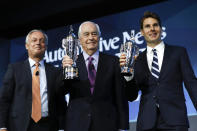 Fred Lissalde, left, president and CEO of BorgWarner; Roger Penske, team owner; and Will Power, right, winner of the 2018 Indianapolis 500, hold their "Baby Borg" driver's and team owner's trophies in Detroit, Wednesday, Jan. 16, 2019. (AP Photo/Paul Sancya)