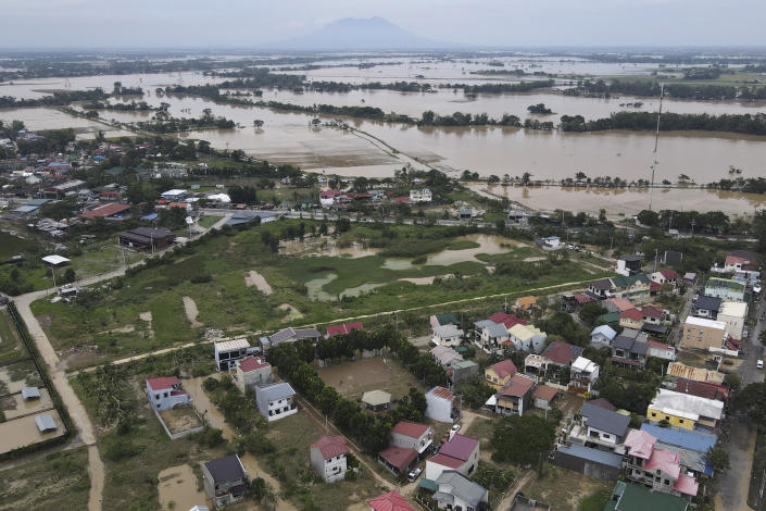 This image taken with a drone, shows flooded residential area and fields due to Typhoon Noru in San Miguel town, Bulacan province, Philippines, Monday, Sept. 26, 2022. Typhoon Noru blew out of the northern Philippines on Monday, leaving some people dead, causing floods and power outages and forcing officials to suspend classes and government work in the capital and outlying provinces. (AP Photo/Aaron Favila)